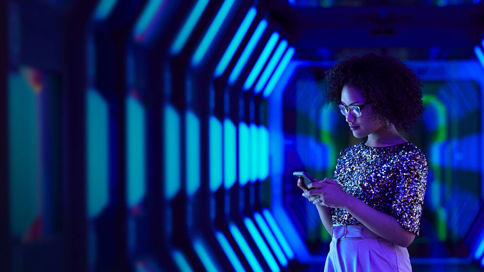 Frau im blauen Tunnel mit Smartphone in der Hand
